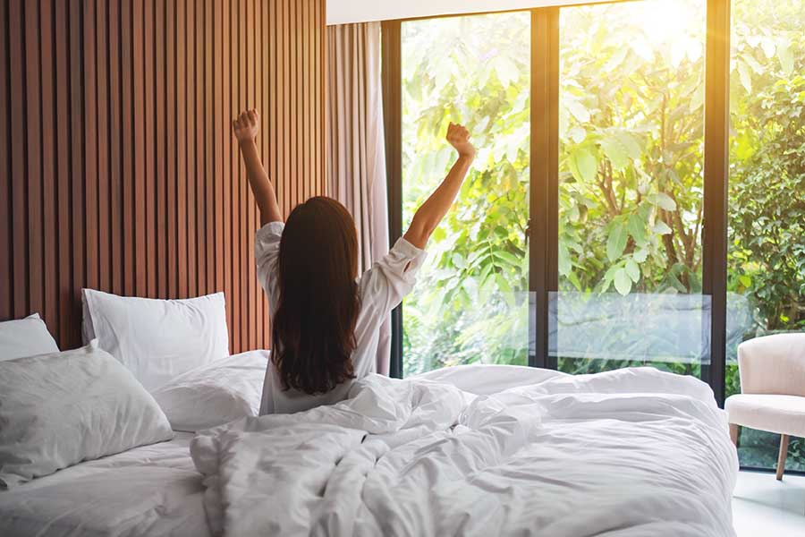woman waking up in a hotel bed